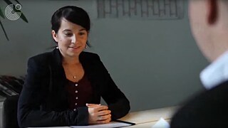  Die junge Frau Nevin sitzt einem Mann gegenüber, der von hinten sichtbar ist.