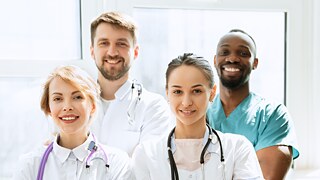 Man sieht vier Personen, die im Krankenhaus arbeiten