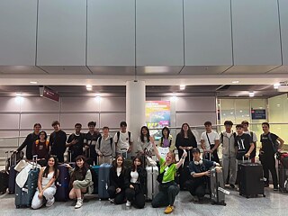 Eine Gruppe Jugendlicher in einer Flughafenankunftshalle