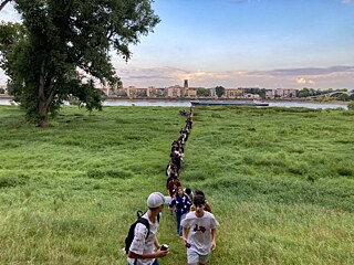 Eine Gruppe Jugendlicher auf einer Wiese nahe der Stadt Köln.