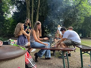Jugendliche sitzen an einem Lagerfeuer