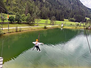 Jugendliche im Flying Fox über einem kleinen See.