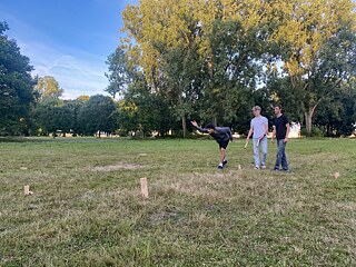 Jugendliche spielen WickingerSchach auf einer Wiese.