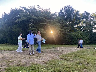 Jugendliche spielen WickingerSchach auf einer Wiese.