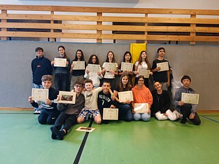 Jugendliche präsentieren stolz ihre Teilnahmebescheinigungen und Zertifikate.