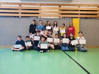 Jugendliche präsentieren stolz ihre Teilnahmebescheinigungen und Zertifikate.