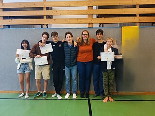 Jugendliche präsentieren stolz ihre Teilnahmebescheinigungen und Zertifikate.