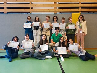 Jugendliche präsentieren stolz ihre Teilnahmebescheinigungen und Zertifikate.