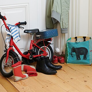 Kinderfahrrad und Schuhe vor einer Wohnungstüre