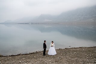 Newlyweds take part in the local tradition of having photos taken on the banks of the Tortkul Reservoir, Kyrgyzstan. 