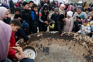 Children help themselves to the last pieces of sumolok at the stadium during the Nooruz celebration in Batken city, Kyrgyzstan. 