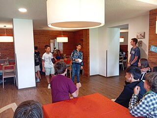 Eine Gruppe lauscht den Ausführungen eines Jugendlichen.
