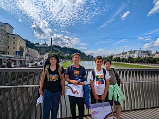 Vier Jugendliche auf einer Brücke über die Salzach.