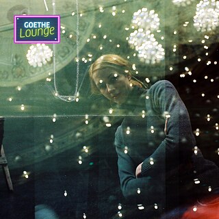 Dancer Tanja Liedtke photographed by Julian Crotti. She is a woman who gazes at the camera, illuminated by colourful lights.