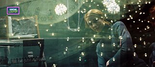 Dancer Tanja Liedtke photographed by Julian Crotti. She is a woman who gazes at the camera, illuminated by colorful lights.