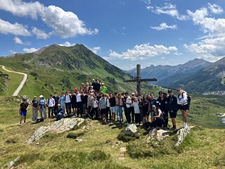 Jugendliche vor einem Gipfelkreuz