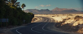 Eine Straße vor dem Hintergrund der Wüste und den Bergen Fuerteventuras