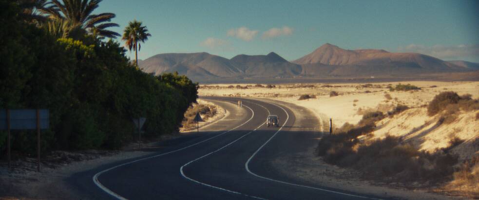 Eine Straße vor dem Hintergrund der Wüste und den Bergen Fuerteventuras