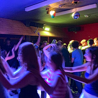 Jugendliche tanzen im Neonlicht.