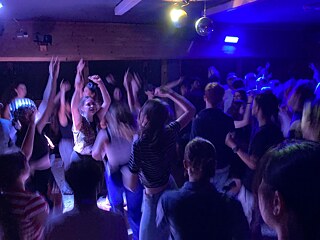 Jugendliche tanzen ausgelassen im Neonlicht.