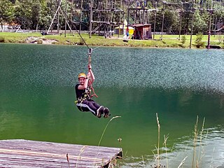 Jugendliche am Flying Fox über einen See.