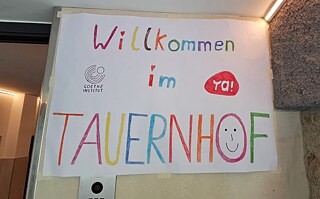 Plakat mit einem Willkommensgruß und dem Logo des Goethe-Instituts und von YA! (Young Austria)