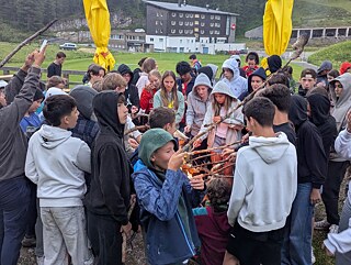 Jugendliche genießen Stockbrot.