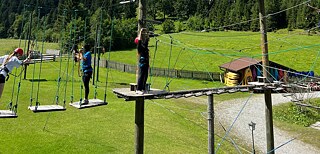 Jugendliche klettern in einem Hochseilgarten