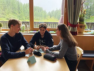 Jugendliche an einem Tisch unterhalten sich angeregt.