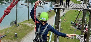 Jugendliche auf einer Slackline in luftiger Höhe.