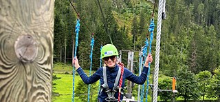 Jugendliche klettern im Hochseilgarten.