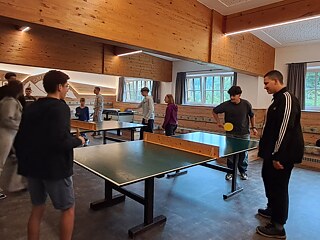 Jugendliche spielen Tischtennis.