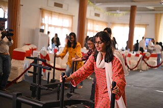 A woman in an event salon, holding many chairs