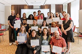 Group photo of the Summer Academy participants and leadership with the certificates of completion of the program