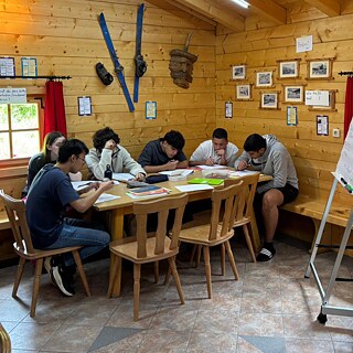 Jugendliche lernen in einer Skihütte.