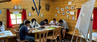 Jugendliche lernen in einer Skihütte.