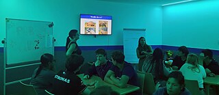 Jugendliche in einem bunt beleuchteten Raum beim Quiz