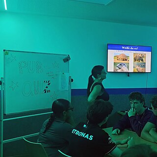 Jugendliche in einem bunt beleuchteten Raum beim Quiz