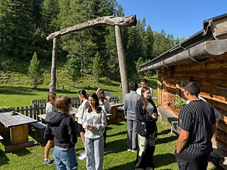 Jugendliche unterhalten sich vor einer Hütte.