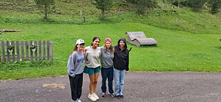 Geschminkte Jugendliche auf einer Wiese in den Bergen.