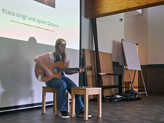Eine junge Frau spielt Gitarre.