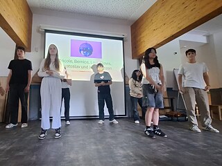 Eine Gruppe Jugendlicher steht auf einer improvisierten Bühne.