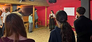 Jugendliche in einem Raum lachen.