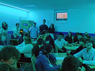 Jugendliche in einem bunt beleuchteten Raum beim Quiz