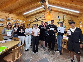 Jugendliche präsentieren selbst gemalte Broschüren.