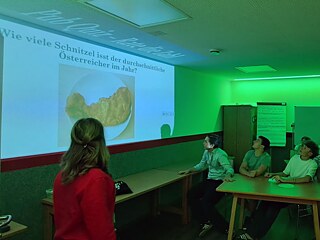 Jugendliche in einem bunt beleuchteten Raum beim Quiz