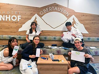 Jugendliche präsentieren selbst gemalte Broschüren.