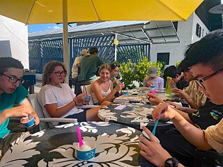 Jugendliche in einem Café verspeisen große Eisbecher.