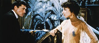 Ein Mann an einem Klavier und eine Frau in einem durchsichtigen Kleid