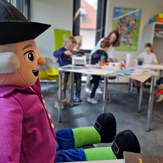 Wolfi schaut den Kindern beim Basteln zu